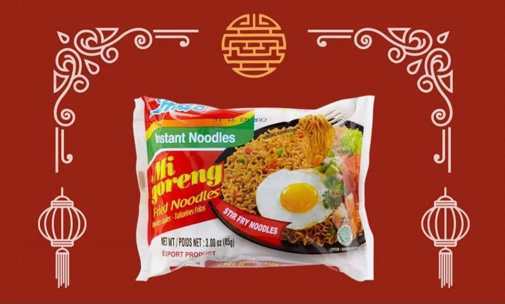 A pack of mi goreng fried noodles displayed against a red background with decorative asian motifs and hanging lantern illustrations, available at MamaFangs.com.