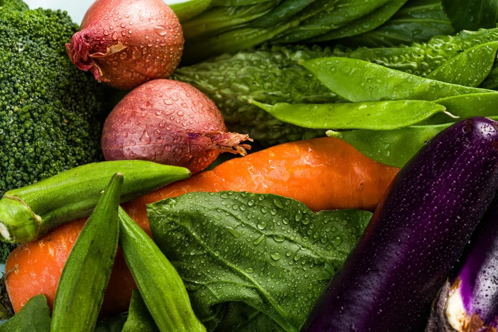 Assorted fresh vegetables with water droplets.