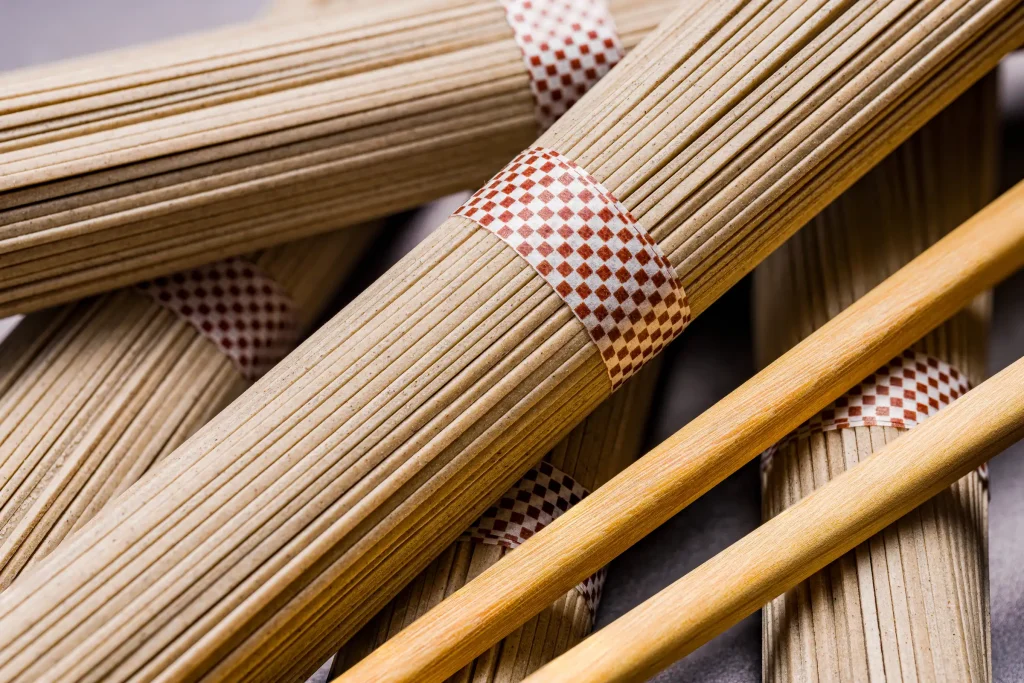 Uncooked italian pasta with decorative red and white patterns on a wooden surface.