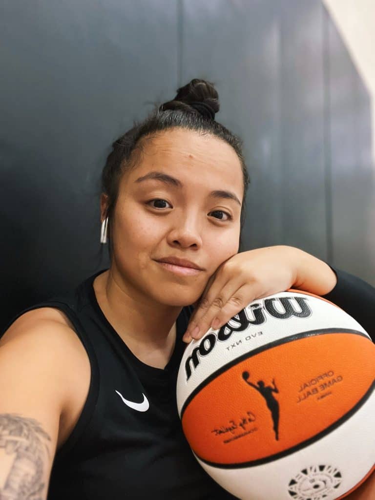 Fitness enthusiast takes a selfie with a basketball, showcasing her love for the game and her favorite post-game Chinese cuisine, Egg Drop Soup.