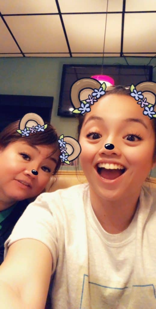 Two people smiling for a selfie with playful bear filter effects on their faces, featuring cute ears, noses, and ingredients reminiscent of Egg Drop Soup.