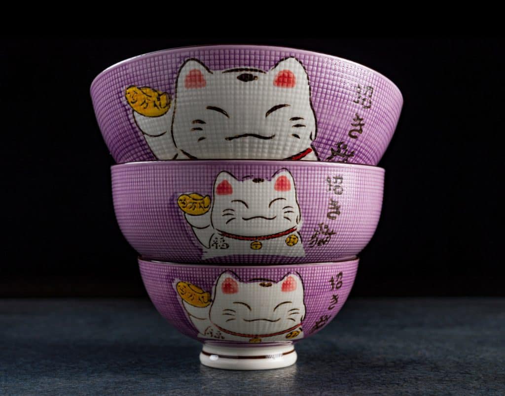 Three stacked bowls with a traditional Japanese maneki-neko (beckoning cat) design, perfect as kitchen accessories.